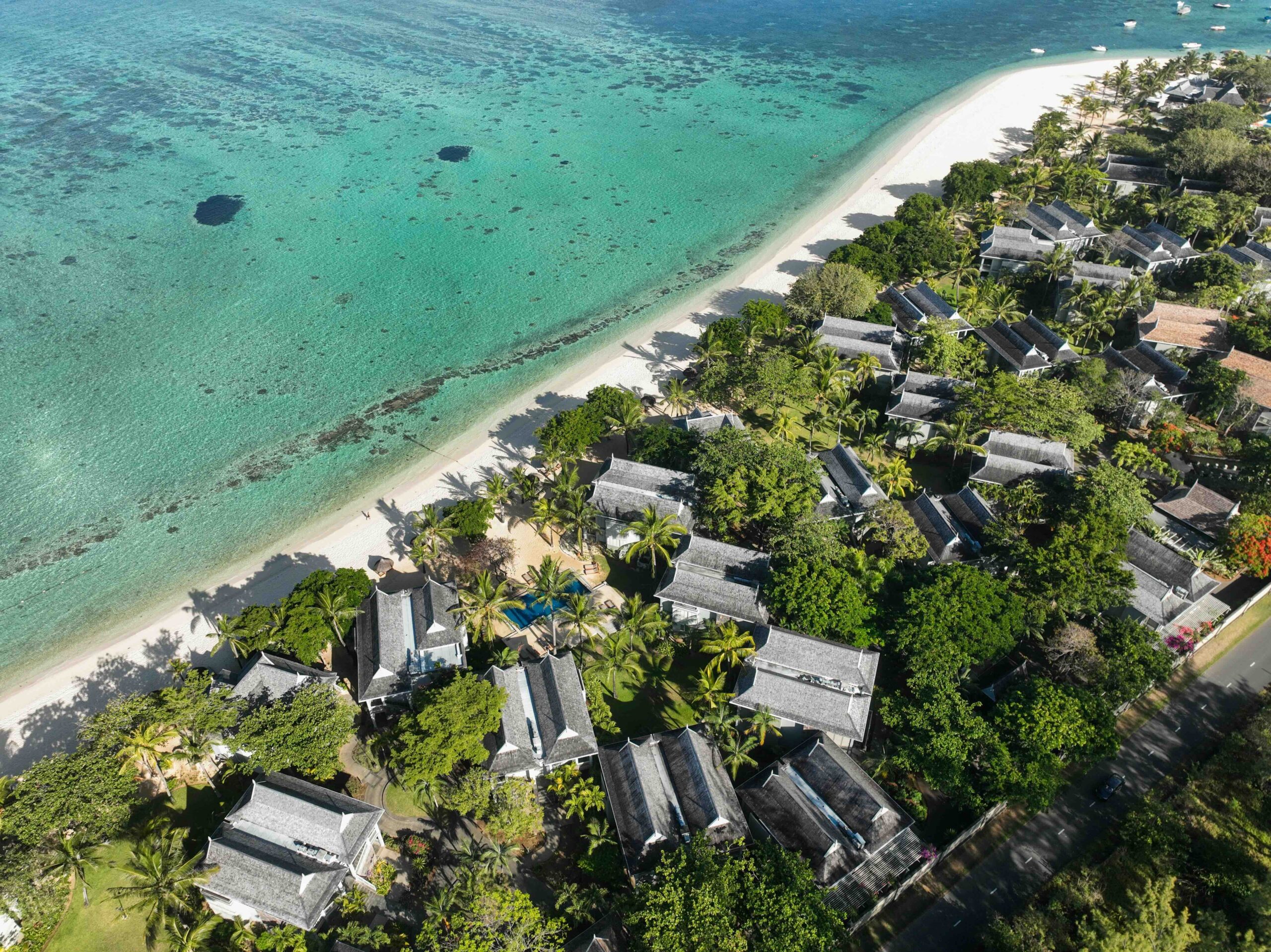 Elevated drone view of Mauritius villas lined along turquoise ocean